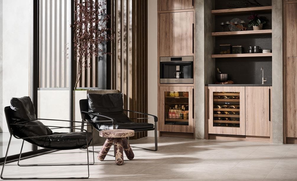 Wolf 24 Inch E Series Transitional Coffee System featured in a luxury coffee bar area with leather swing back chairs